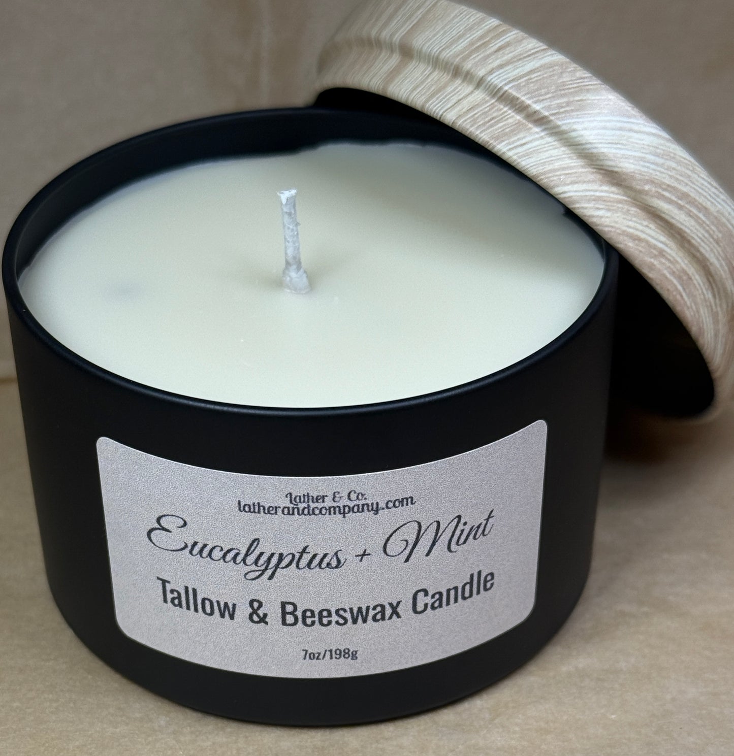Black candle with a label on a beige background