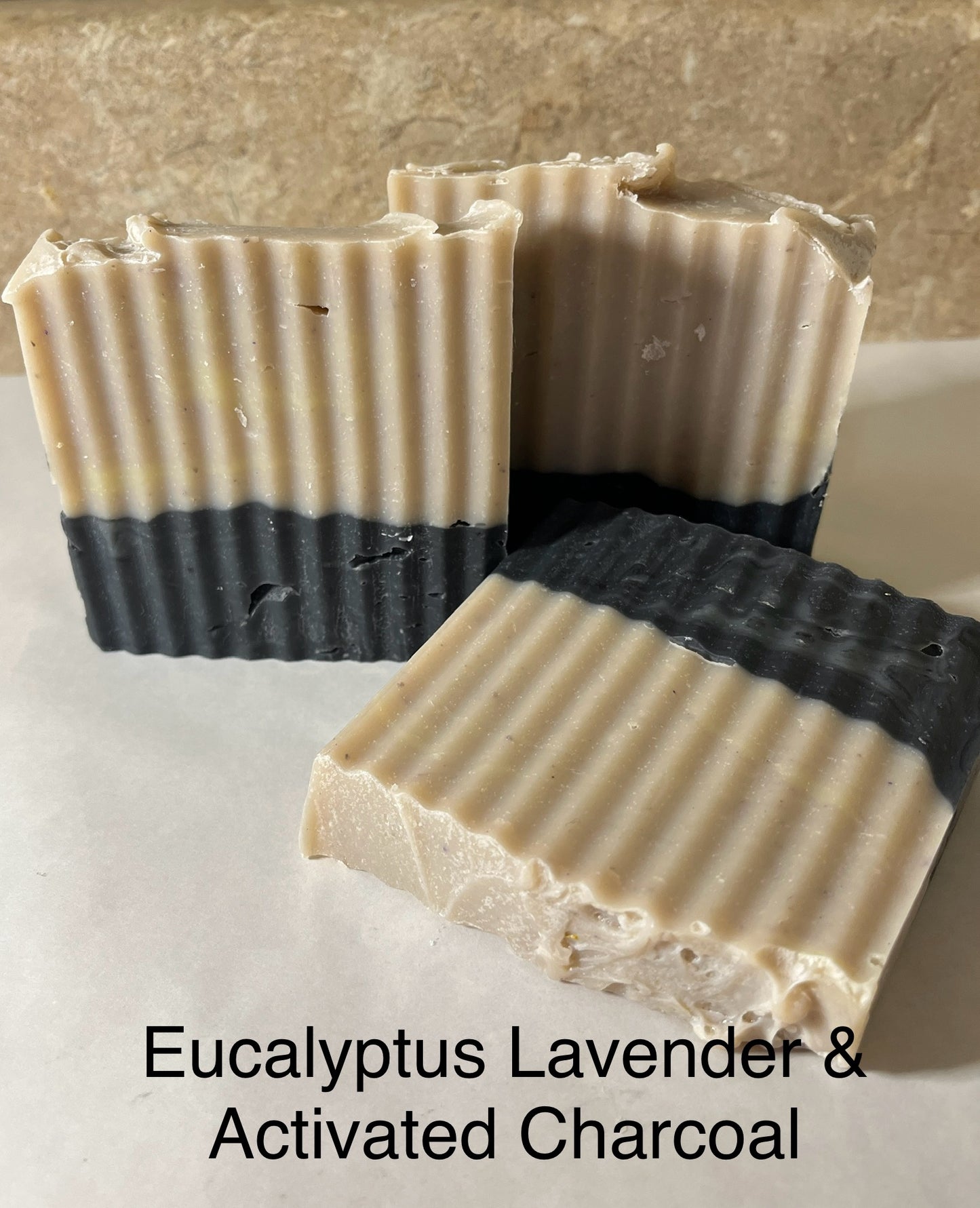 Two bars of Eucalyptus Lavender & Activated Charcoal soap on a neutral background