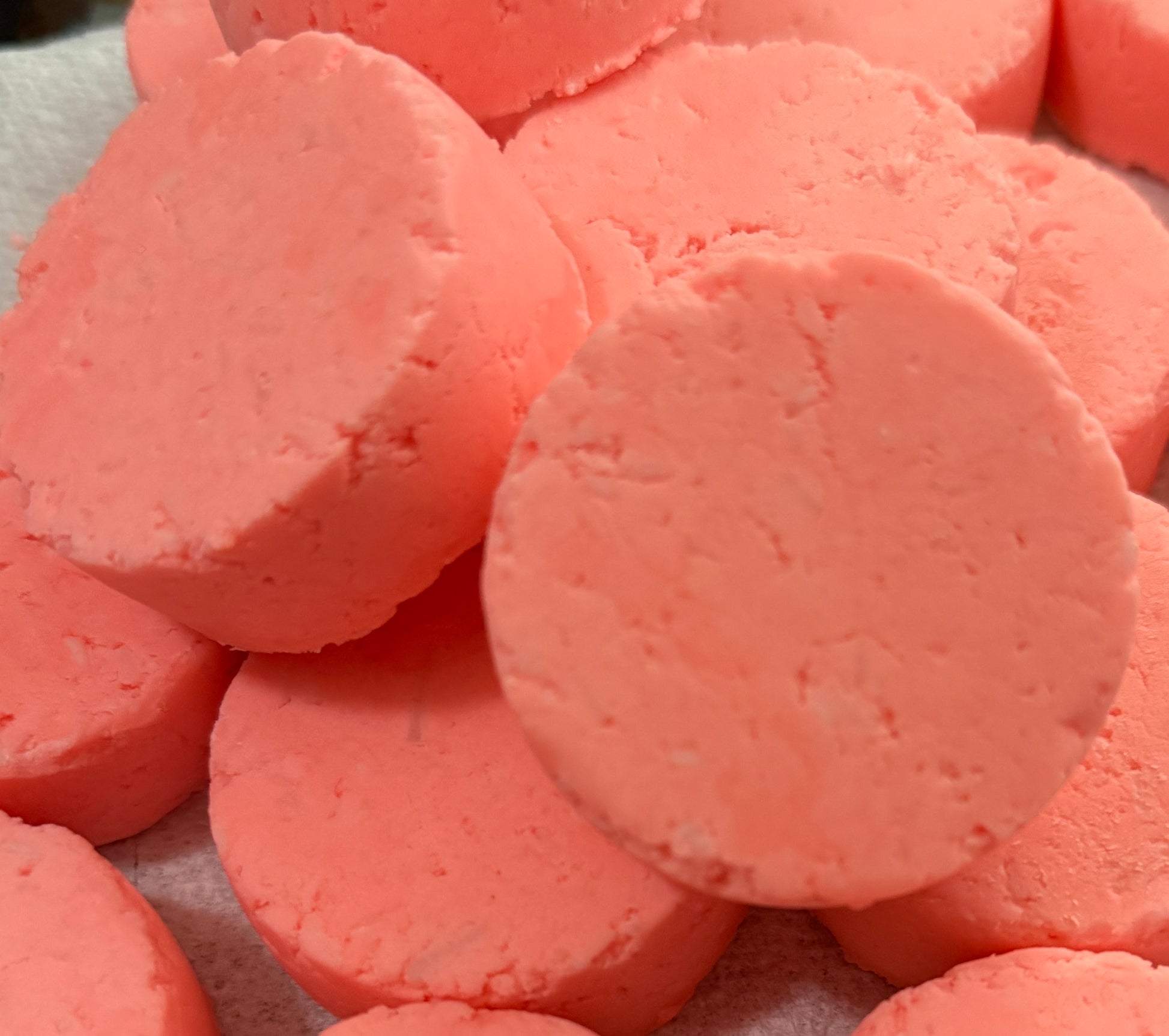Close-up of pink bath bombs on a white surface