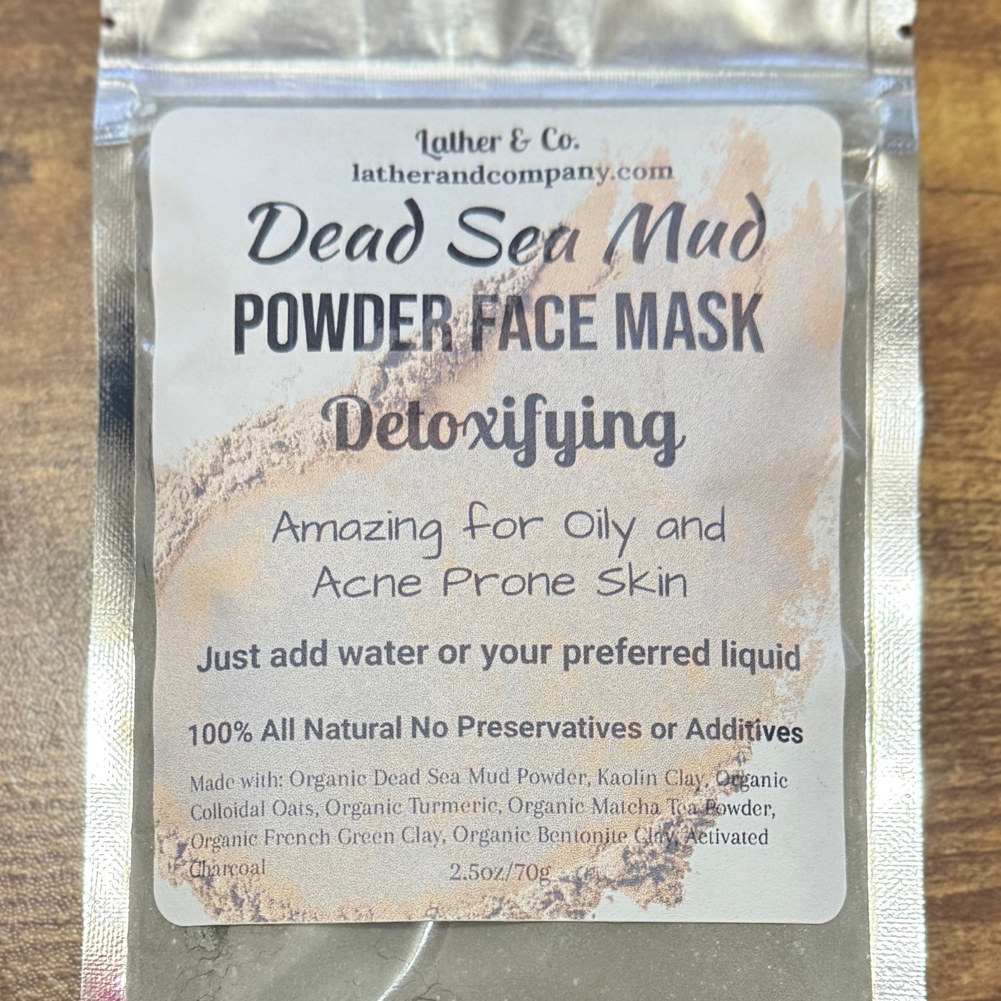 Dead Sea Mud Powder Face Mask packaging with text on a wooden surface