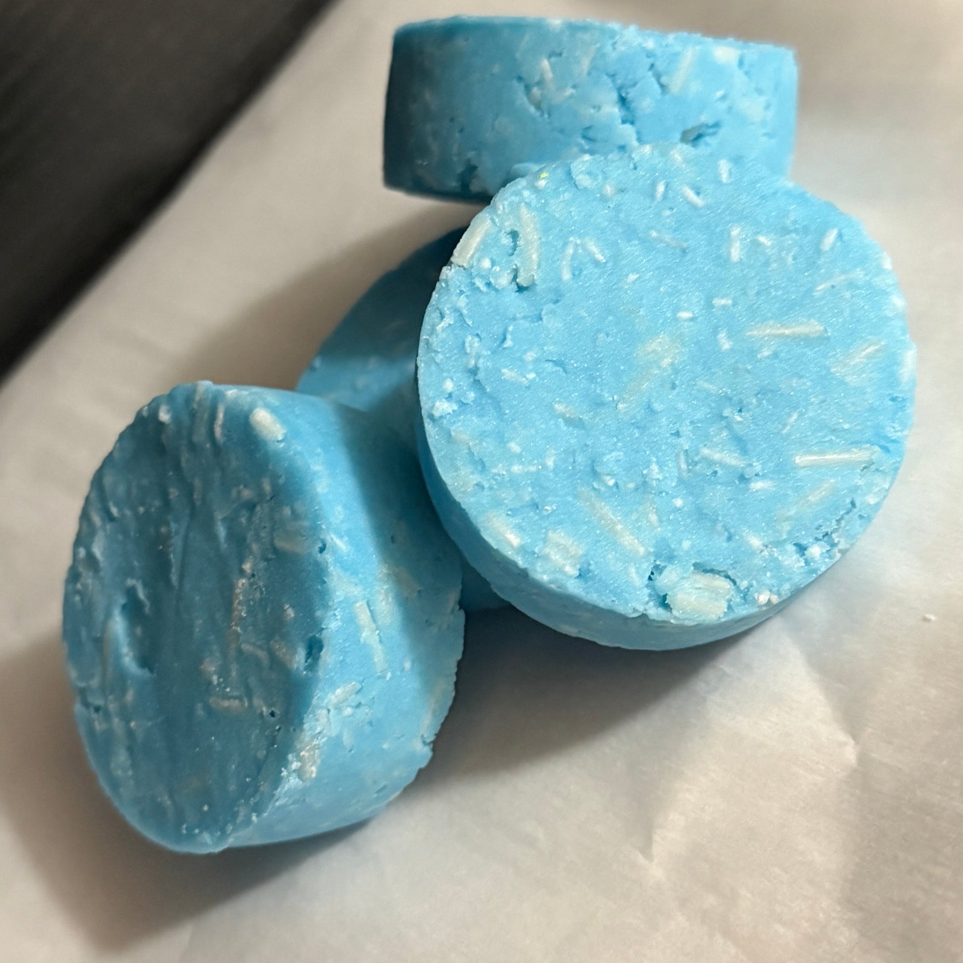 Two blue bath bombs with a textured surface on a light background