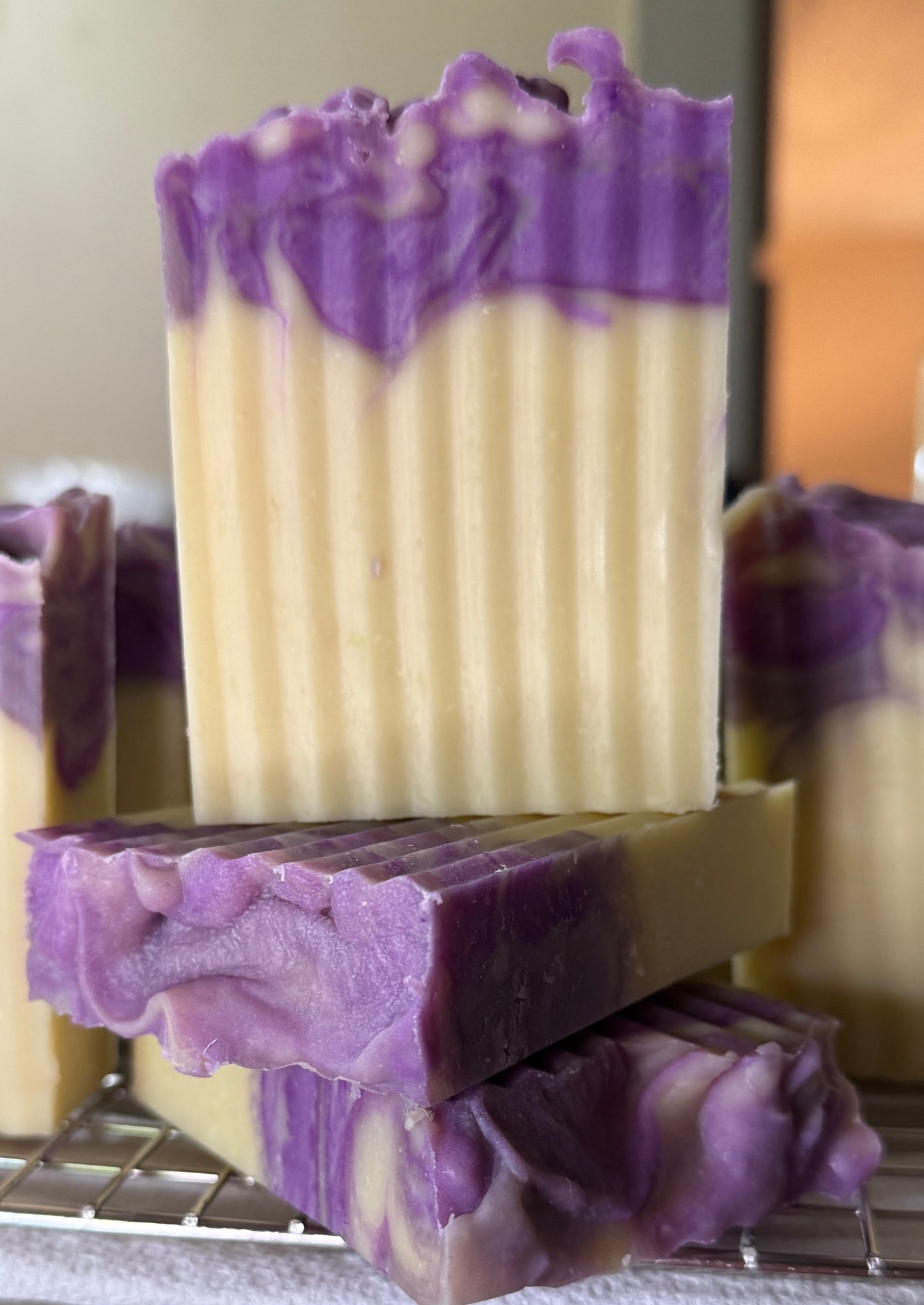 Stack of purple and white soap bars on a metal rack.